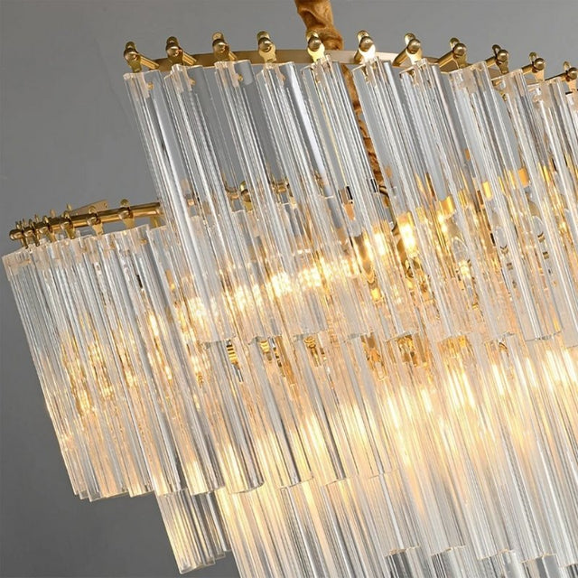 "A close-up view of a tiered chandelier with clear crystal rods and a brass frame, showing the texture and light reflection."