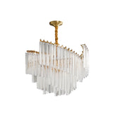 "A tiered chandelier with clear crystal rods and a brass frame, isolated on a white background."