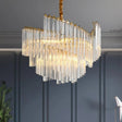 "A layered chandelier with clear crystal rods, suspended from a brass frame, casting a warm light."