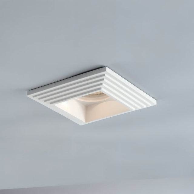 "Recessed square downlight made from gypsum and aluminum with ribbed edges, offering focused, glare-free illumination in modern kitchens, living rooms, and offices."