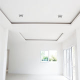 "Two square recessed downlights made from gypsum and aluminum with ribbed edges, offering glare-free, focused lighting in contemporary spaces like living rooms and offices."