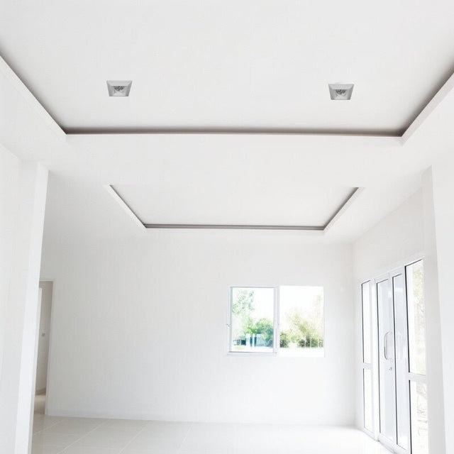 "Two square recessed downlights made from gypsum and aluminum with ribbed edges, offering glare-free, focused lighting in contemporary spaces like living rooms and offices."