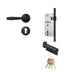Black door handle set with mortise lock, cylinder, and brass keys on white background.