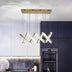 Modern brass and crystal linear chandelier with adjustable hanging rods suspended above a contemporary kitchen with dark cabinetry.