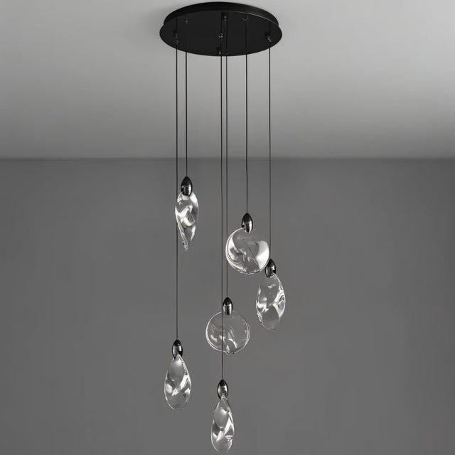 "Pendant lights with uniquely shaped crystal droplets hang from a round, black canopy against a grey background."