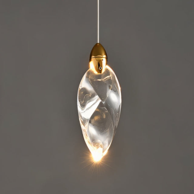 "A single, leaf-shaped crystal pendant light with gold hardware, casting a warm glow against a grey background."