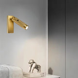 "Wall-mounted modern bedside reading lamp with adjustable light direction, featuring a textured polished metal design and USB connection, placed beside decor items."