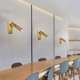 "Multiple modern bedside reading lamps with a textured polished metal finish, wall-mounted with adjustable light direction, enhancing a contemporary space."