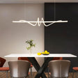"A modern white linear pendant light with wave-like curves, hanging above a dining table in a modern dining room."