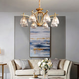 "Gold chandelier with six glass shades hanging over a living room sofa."