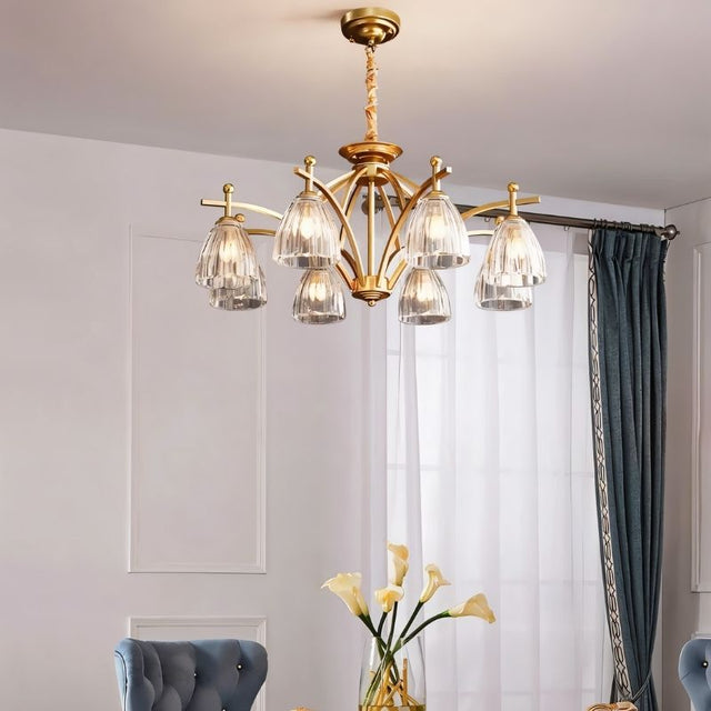 "Gold chandelier with eight glass shades hanging over a dining room table."
