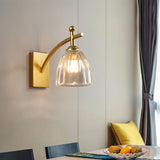 "A gold wall lamp with fluted glass shade in a dining room setting."