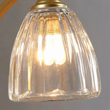 "A close-up detail of the gold wall lamp's fluted glass shade."