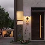 "A modern, cylindrical Luminturs 6W LED outdoor wall light mounted on a textured wall next to a dark wooden door."