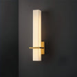 "Modern wall lamp with an alabaster shade and brass accents, mounted on a dark wall, providing soft ambient lighting"