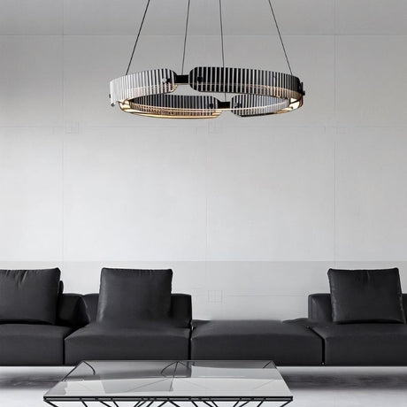 "A modern, circular chandelier with a segmented ring design, made of iron and glass, suspended by thin cables in a minimalist living space."