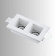 "Trimless recessed downlight fixture with dual square openings, crafted from gypsum and aluminum, offering a sleek and minimalist design for focused, efficient lighting."