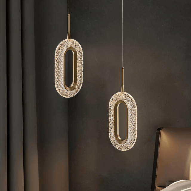 Luxin Sculptural Pendant Light with dual oval LED fixtures in copper and acrylic, creating ambient lighting in a modern bedroom setting.