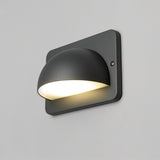 "A modern, dome-shaped outdoor wall lamp casting a soft, downward light on a light gray wall."