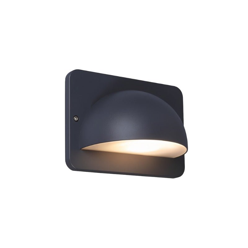"A lit, modern dome-shaped outdoor wall lamp with a square base and PC diffuser, isolated on a white background."