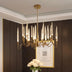 Gold chandelier with crystal spires illuminates a dark wood paneled room with white ceiling trim.