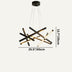 Modern black and gold starburst chandelier with cylindrical arms suspended against a white background.