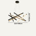 Modern pendant chandelier with black and brass crossed rod design, suspended against a light background.