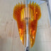 Amber glass chandelier with layered petal design hanging in white interior space.