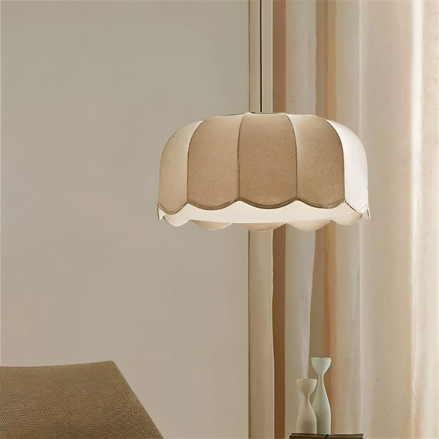 "Mashi pendant light with a fabric shade hanging in a living room, close-up view with a beige armchair."