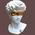 White marble bust of David with gold foil eye mask against brown background.