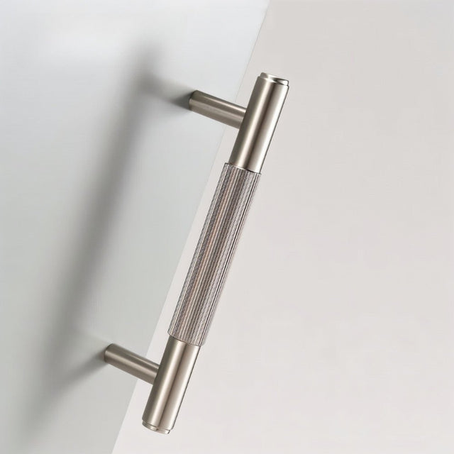 "Modern brushed nickel brass knurled pull handle for a cabinet or drawer."