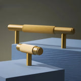 "Modern gold brass drawer knobs and pull bars with a textured, knurled grip on a blue background."