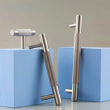 "Modern brass T-bar cabinet pulls and knobs with a textured, knurled grip on a blue and gray background."