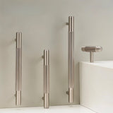 "Modern brass knurled T-bar pulls and knobs for cabinets and drawers on a gray background."