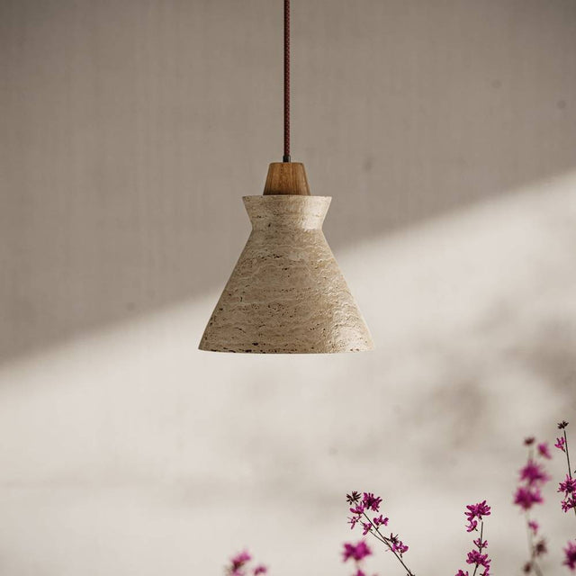 Menra Pendant Light with travertine and wood materials, suspended in a softly lit room with floral accents for cozy ambiance.