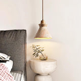 Menra Pendant Light beside a bed, enhancing bedroom ambiance with its natural stone texture and warm lighting effect.