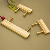 "Set of sleek geometric brushed brass pull bars with screws on a neutral background."
