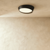 White flush mount ceiling lights with brass trim, overhead view in modern white hallway interior.