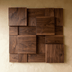 Three-dimensional wooden wall panels in varying warm brown tones arranged in an offset pattern, photographed at an angle agai