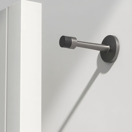 "Sleek, cylindrical door stop in brushed nickel zinc-alloy with extended arm, wall-mounted to prevent a door from hitting the wall in a modern interior."