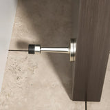 "Sleek, cylindrical door stop with extended arm, wall-mounted to prevent a door from hitting and damaging the wall in a modern interior."