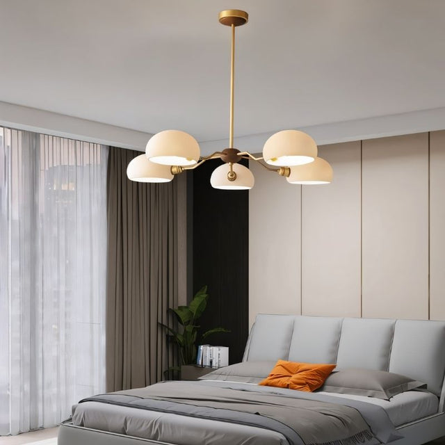 "A five-light chandelier with frosted glass shades hangs in a modern bedroom with a large window."