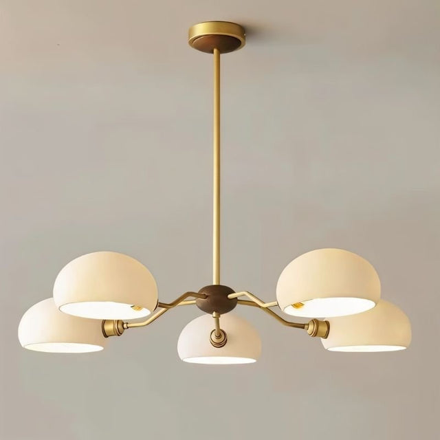 "A modern chandelier with dome-shaped glass shades and a copper frame illuminates a contemporary space."