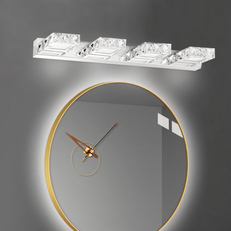 "A modern crystal wall sconce mounted above a round, gold-framed mirror with a clock face in a dimly lit bathroom."
