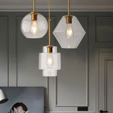 "Three modern pendant lights with clear glass shades in different shapes, hanging together."