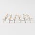 Three groups of cream-colored mushroom-shaped outdoor lamps with dark stems arranged on a white surface.