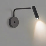 "A black wall lamp with a pivoting arm and cylindrical head, lit up on a gray wall."