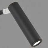 "A close-up of the lit cylindrical head of a black wall lamp with a pivoting arm."