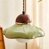 "Handcrafted pendant light with a curved ceramic shade and wooden top, blending vintage and modern design elements."