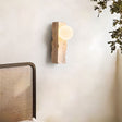 "travertine wall lamp with frosted glass globe mounted on a bedroom wall"